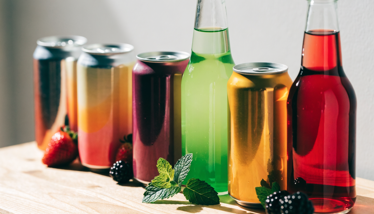 Assortiment de canettes et bouteilles de boissons fonctionnelles sur une surface en bois clair